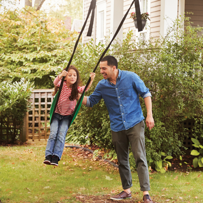 dad pushing daughter on swing